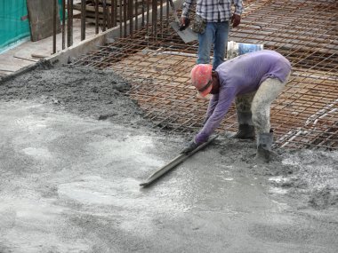 Kuala Lumpur, Malezya -05 Eylül 2017: İnşaat işçileri ıslak beton doldu. Onlar da bu iş için uzun mala kullanarak. 