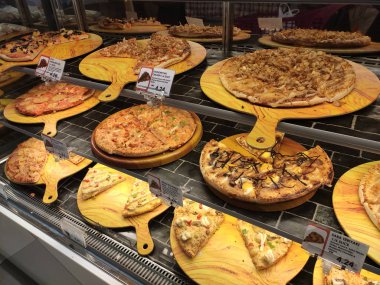 Kuala Lumpur, Malezya -16 Temmuz 2019: Sıcak pizzalar, alışveriş merkezindeki cam ısıtıcının içinde satışa sunulan rafta sergileniyor. Çeşitli tip pizzalar müşterilere sunulmaktadır.