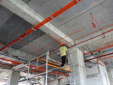 Kuala Lumpur, Malezya -26 Mayıs 2017: İnşaat işçileri elektrik kablosu tepsisi kuruyor ve şantiyede kablolama işleri yapıyor. 