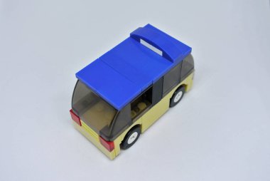 Plastik tuğladan yapılmış ve beyaz arka plan üzerine izole edilmiş küçük oyuncak otobüs odaklı seçilen. 