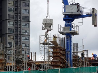 Kuala Lumpur, Malezya -26 Temmuz 2017: Şantiyede inşaat işçileri tarafından konkret çalışmaları. Isıl beton kereste formu iş içine dökülür.  
