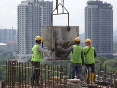 Kuala Lumpur, Malezya -26 Temmuz 2017: Şantiyede inşaat işçileri tarafından konkret çalışmaları. Isıl beton kereste formu iş içine dökülür.  