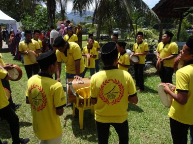 Kuala Lumpur, Malezya -27 Ocak 2018: Çocuk Malay düğün töreninde Kompang'ı oynuyor. Kompang genellikle geleneksel Malay düğün sırasında oynanan bir Malay geleneksel davul olduğunu