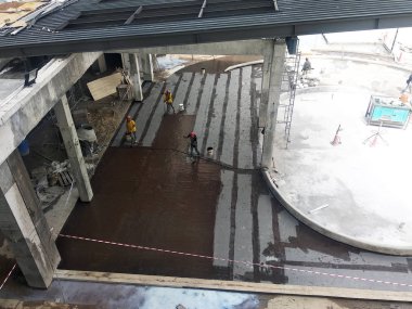 Kuala Lumpur, Malezya -25 Temmuz 2018: Beton levhaüzerine inşaat işçileri tarafından uygulanan su yalıtım membranı. Suyun beton levhanın altına girmesini önlemek için su yalıtım tabakası. 