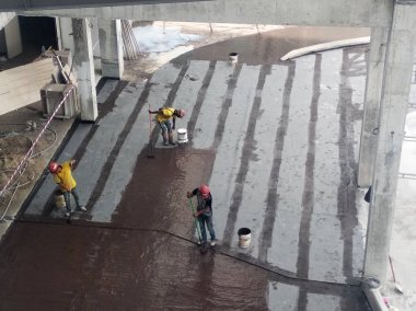 Kuala Lumpur, Malezya -25 Temmuz 2018: Beton levhaüzerine inşaat işçileri tarafından uygulanan su yalıtım membranı. Suyun beton levhanın altına girmesini önlemek için su yalıtım tabakası. 