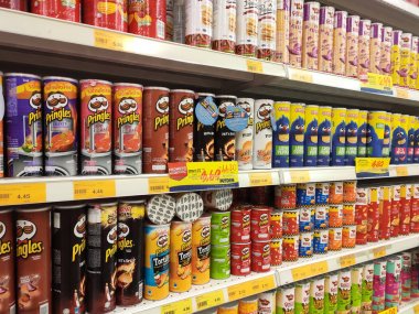 KUALA LUMPUR, MALAYSIA -JULY 28, 2019: Packed miscellaneous junk foods & snacks on rack and display for sale in the supermarket. Unhealthy food especially for kids.  clipart