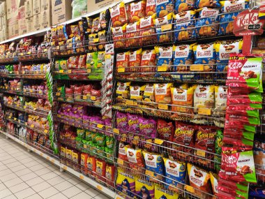 Kuala Lumpur, Malezya-28 Temmuz 2019: Paketli çeşitli önemsiz gıdalar ve raf ve süpermarket Satılık ekran aperatifler. Özellikle çocuklar için sağlıksız gıda. 