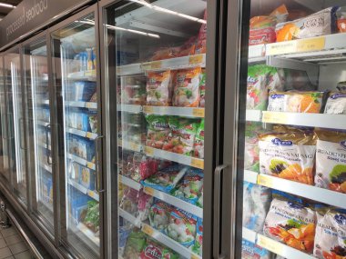 Kuala Lumpur, Malezya -30 Temmuz 2019: Süpermarketteki büyük soğutucunun içinde rafta sergilenen dondurulmuş yiyecekler. Müşterinin seçmesini kolaylaştırmak için marka tarafından görüntülenen ve düzenlenen. 