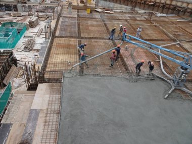Kuala Lumpur, Malezya -16 Ocak 2018: İnşaat işçileri beton örümcek hortumu kullanarak beton beton dökerek şantiyede levha formunda çalışma yaptı. 