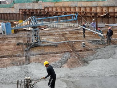 Kuala Lumpur, Malezya -16 Ocak 2018: İnşaat işçileri beton örümcek hortumu kullanarak beton beton dökerek şantiyede levha formunda çalışma yaptı. 