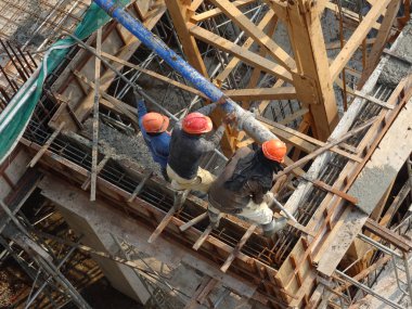 Kuala Lumpur, Malezya -16 Ocak 2018: İnşaat işçileri beton örümcek hortumu kullanarak beton beton dökerek şantiyede levha formunda çalışma yaptı. 