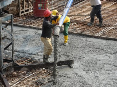 Kuala Lumpur, Malezya -16 Ocak 2018: İnşaat işçileri beton örümcek hortumu kullanarak beton beton dökerek şantiyede levha formunda çalışma yaptı. 