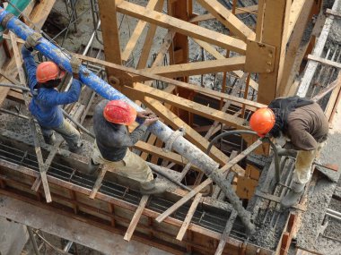 Kuala Lumpur, Malezya -16 Ocak 2018: İnşaat işçileri beton örümcek hortumu kullanarak beton beton dökerek şantiyede levha formunda çalışma yaptı. 