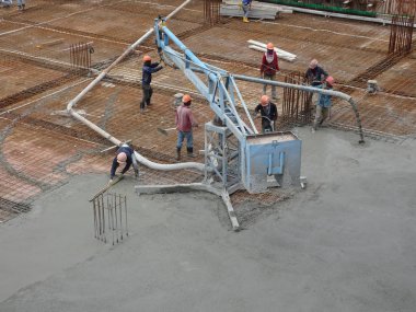 Kuala Lumpur, Malezya -16 Ocak 2018: İnşaat işçileri beton örümcek hortumu kullanarak beton beton dökerek şantiyede levha formunda çalışma yaptı. 