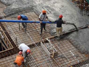 Kuala Lumpur, Malezya -16 Ocak 2018: İnşaat işçileri beton örümcek hortumu kullanarak beton beton dökerek şantiyede levha formunda çalışma yaptı. 