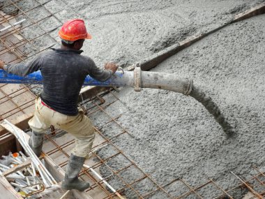 Kuala Lumpur, Malezya -16 Ocak 2018: İnşaat işçileri beton örümcek hortumu kullanarak beton beton dökerek şantiyede levha formunda çalışma yaptı. 