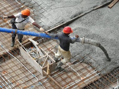 Kuala Lumpur, Malezya -16 Ocak 2018: İnşaat işçileri beton örümcek hortumu kullanarak beton beton dökerek şantiyede levha formunda çalışma yaptı. 