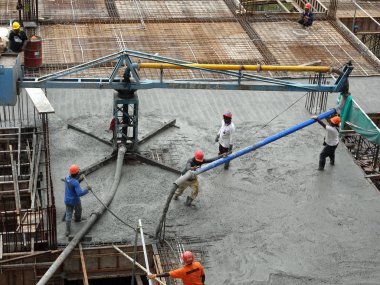 Kuala Lumpur, Malezya -16 Ocak 2018: İnşaat işçileri beton örümcek hortumu kullanarak beton beton dökerek şantiyede levha formunda çalışma yaptı. 