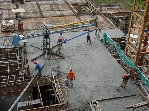 Kuala Lumpur, Malezya -16 Ocak 2018: İnşaat işçileri beton örümcek hortumu kullanarak beton beton dökerek şantiyede levha formunda çalışma yaptı. 