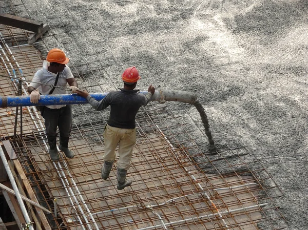 Kuala Lumpur, Malezya -16 Ocak 2018: İnşaat işçileri beton örümcek hortumu kullanarak beton beton dökerek şantiyede levha formunda çalışma yaptı. 