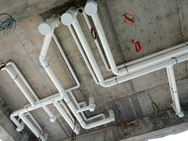 KUALA LUMPUR, MALAYSIA -JANUARY 15, 2018: UPVC sewerage pipe below toilet's soffit under construction at the construction site. The pipes connected together and channels to the main sewer. 