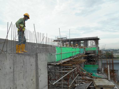 Kuala Lumpur, Malezya -16 Temmuz 2017: Büyük şantiyede çalışan inşaat işçileri. Kazanın olmasını önlemek için uygun güvenlik donanımı takmak. 