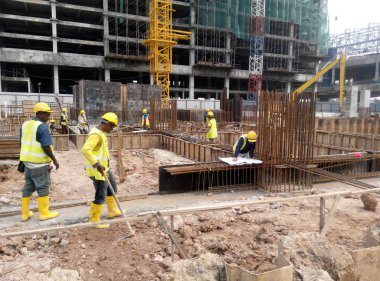 Kuala Lumpur, Malezya -16 Temmuz 2017: Büyük şantiyede çalışan inşaat işçileri. Kazanın olmasını önlemek için uygun güvenlik donanımı takmak. 