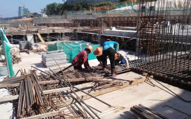 Kuala Lumpur, Malezya -16 Temmuz 2017: Büyük şantiyede çalışan inşaat işçileri. Kazanın olmasını önlemek için uygun güvenlik donanımı takmak. 