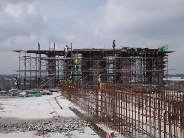 Kuala Lumpur, Malezya -16 Temmuz 2017: Büyük şantiyede çalışan inşaat işçileri. Kazanın olmasını önlemek için uygun güvenlik donanımı takmak. 