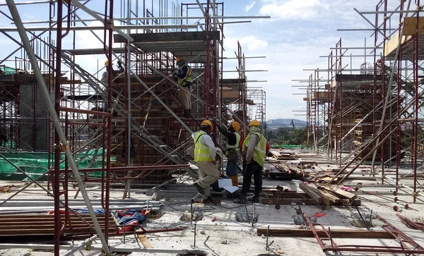 Kuala Lumpur, Malezya -16 Temmuz 2017: Büyük şantiyede çalışan inşaat işçileri. Kazanın olmasını önlemek için uygun güvenlik donanımı takmak. 