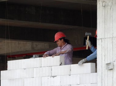 Kuala Lumpur, Malezya -04 Mart 2017: İnşaat işçileri şantiyede duvar haline hafif blok tuğla lar döşeyerek. Blok özel yapıştırıcı kullanılarak birlikte bağ oldu. 