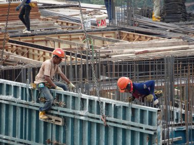 Kuala Lumpur, Malezya -10 Ağustos 2017: Şantiyede inşaat işçileri. Kazayı önlemek için uygun güvenlik donanımı takmak. 