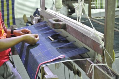 Kuala Lumpur, Malezya -25 Haziran 2016: Geleneksel dokuma makinesi bir Malay kadını tarafından işletilen.