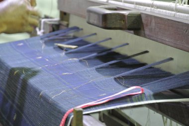 Kuala Lumpur, Malezya -25 Haziran 2016: Geleneksel dokuma makinesi bir Malay kadını tarafından işletilen.