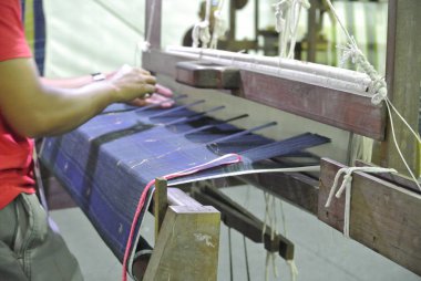 Kuala Lumpur, Malezya -25 Haziran 2016: Geleneksel dokuma makinesi bir Malay kadını tarafından işletilen.