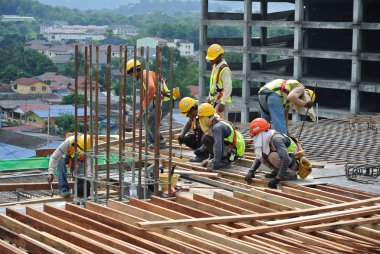 SEREMBAN, MALAYSIA -HAZİRAN 01 HAZİRAN 2016: Gündüz Malezya 'nın Seremban kentindeki şantiyede çalışan inşaat işçileri. Güvenli bir şekilde çalıştıklarından emin olmak için gerekli güvenlik ekipmanlarını giyiyorlar.. 