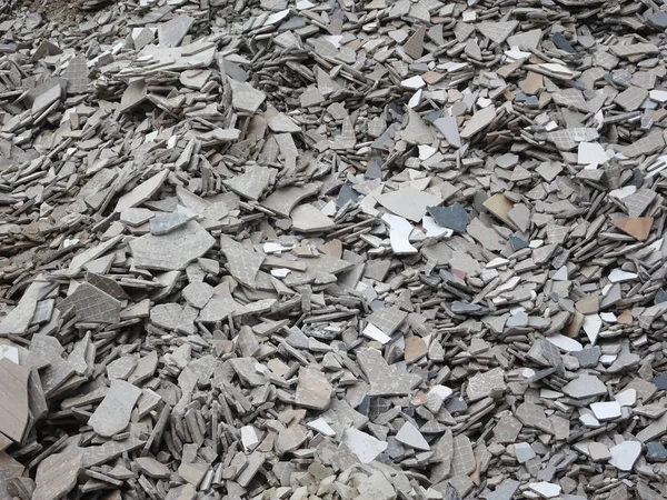 Broken homogeneous and ceramic floor tiles. Broken tiles are collected in one area before being processed and reused.