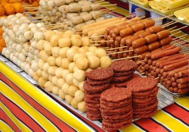 Kuala Lumpur, Malezya - 25 Mart 2017: Sosisler ve diğer işlenmiş gıdalar şişlerle gagalanır ve servis edilir. Gece pazarında sokak satıcıları tarafından satılıyor.. 