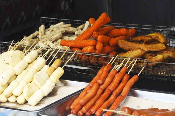 KUALA LUMPUR, MALAYSIA - MARCH 25, 2017: Sausages and other processed foods are pecked with skewers and served. Sell by street hawkers in the night market.