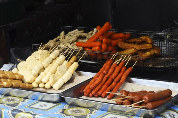 KUALA LUMPUR, MALAYSIA - MARCH 25, 2017: Sausages and other processed foods are pecked with skewers and served. Sell by street hawkers in the night market.