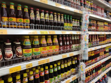 Kuala Lumpur, Malezya - 11 Mayıs 2019: Süpermarketlerde satılmak üzere sergilenen şişelerde seçici odaklı pişirme sosu. Raflarda görüntülendi ve alıcıları kolaylaştırmak için marka tarafından ayrıldı.