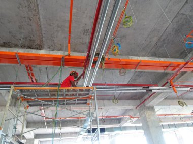 Kuala Lumpur, Malezya - 15 Mayıs 2018: İnşaatta tavandan yukarı kurulmuş hizmetlerin bir parçası olarak elektrik kanalı, kablo tepsisi ve havalandırma boruları. 