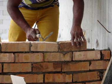 Kuala Lumpur, Malezya-29 Mart 2017: bricklayer kil tuğla yatıyordu ve inşaat yerinde duvarlar oluşturmak için çimento harç kullanarak birlikte yığılmış. Bu iş için gerekli araçlar gereklidir. 