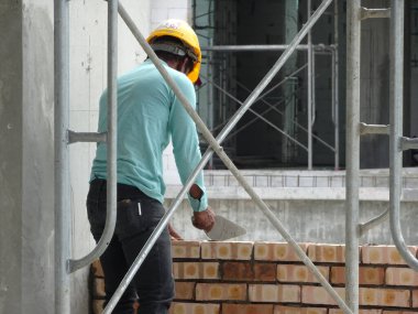 Kuala Lumpur, Malezya-29 Mart 2017: bricklayer kil tuğla yatıyordu ve inşaat yerinde duvarlar oluşturmak için çimento harç kullanarak birlikte yığılmış. Bu iş için gerekli araçlar gereklidir. 