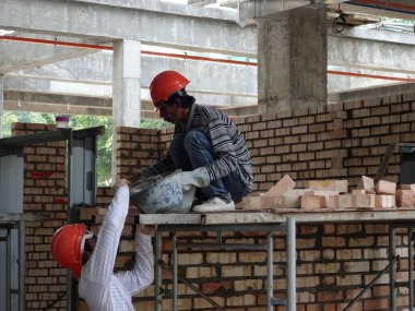 Kuala Lumpur, Malezya-29 Mart 2017: bricklayer kil tuğla yatıyordu ve inşaat yerinde duvarlar oluşturmak için çimento harç kullanarak birlikte yığılmış. Bu iş için gerekli araçlar gereklidir. 