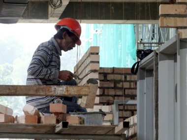 Kuala Lumpur, Malezya-29 Mart 2017: bricklayer kil tuğla yatıyordu ve inşaat yerinde duvarlar oluşturmak için çimento harç kullanarak birlikte yığılmış. Bu iş için gerekli araçlar gereklidir. 