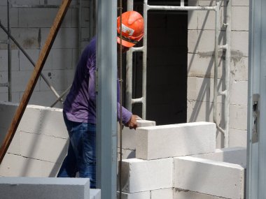 Kuala Lumpur, Malezya - 29 Mart 2017: İnşaat işçileri inşaat alanında duvar olmak için hafif blok tuğlaları kuruyorlar. Blok özel bir yapıştırıcı kullanılarak birbirine bağlanmıştı.. 