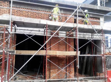 Kuala Lumpur, Malezya-29 Mart 2017: bricklayer kil tuğla yatıyordu ve inşaat yerinde duvarlar oluşturmak için çimento harç kullanarak birlikte yığılmış. Bu iş için gerekli araçlar gereklidir. 
