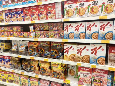 KUALA LUMPUR, MALAYSIA - 17 Mayıs 2019: Karton kutuda ve plastik pakette mısır gevreği. Dev süpermarketlerde raflarda sergileniyordu. Markaya göre sıralanır. 