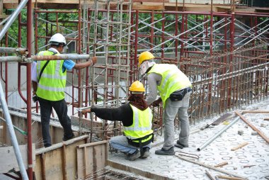 MALACCA, MALAYSIA -27 Mayıs 2016: Malezya 'daki inşaat alanında çelik takviye barı üreten inşaat işçileri. Destek çubuğu ince bir kabloyla birbirine bağlanmış..  